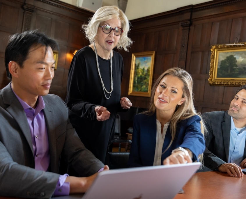 FELTG-041 Course instructor looking over the shoulder of two course attendees at laptop screen