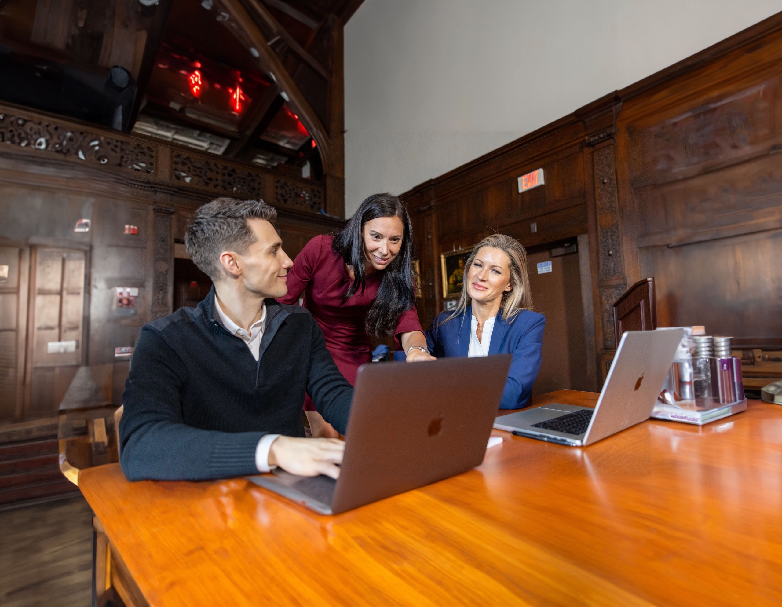 FELTG-249 Course instructor looking over the shoulder of two course attendees at laptop screen
